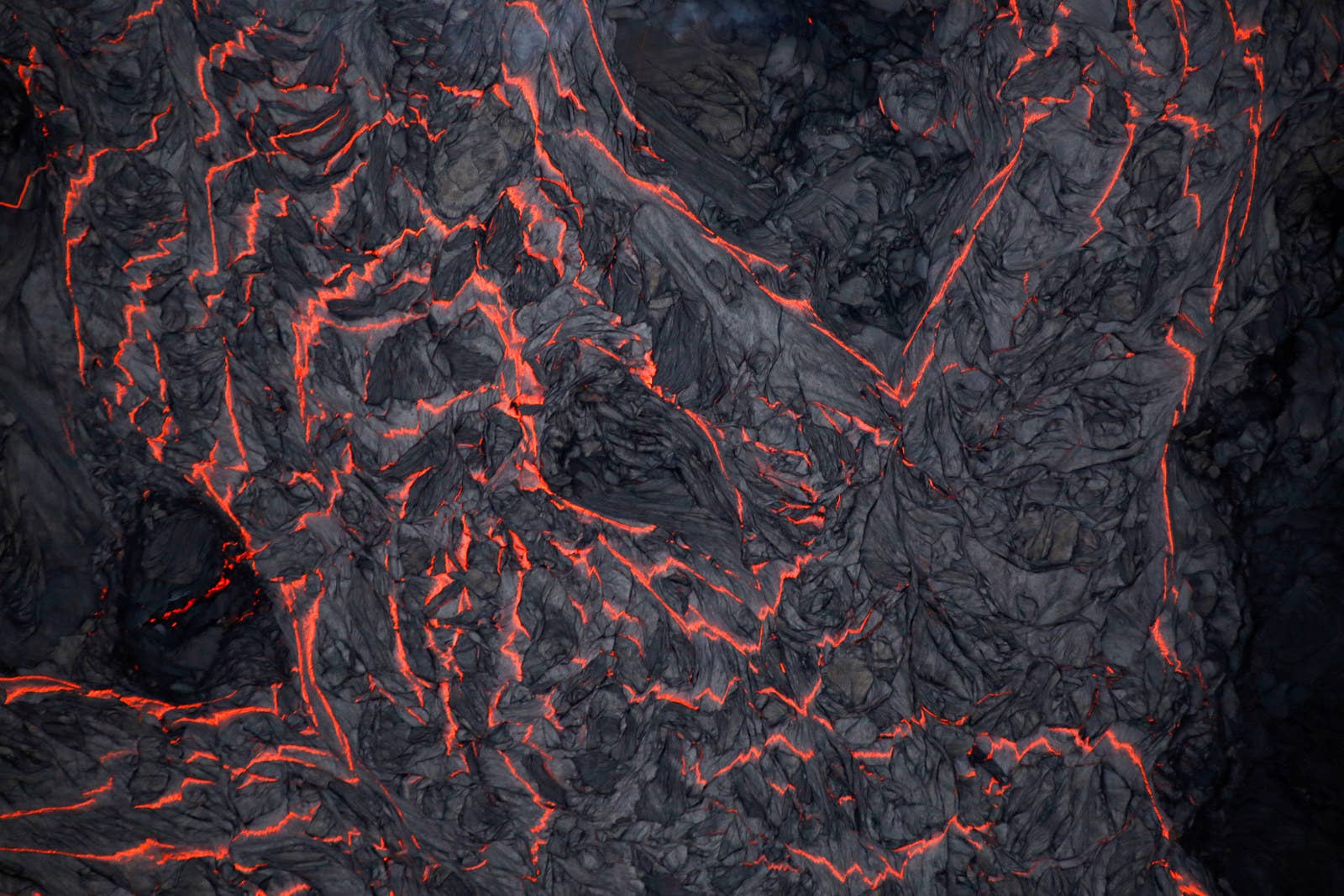 An aerial view of a river of lava, with some of it hardening on top.