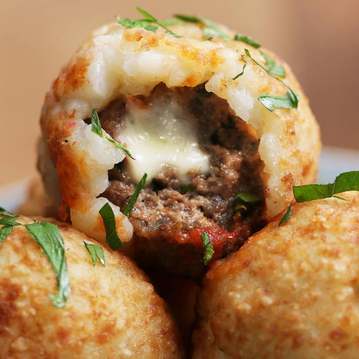 Porções 8Você vai precisar de: 450g de carne moída1 ovo1 xícara de queijo parmesão ralado1 xícara de salsinha picada1 colher de sopa de sal1 colher de sopa de pimenta½ xícara de queijo muçarela em cubinhos3 xícaras de purê de batata2 xícaras de farinha de trigo4 xícaras de óleo vegetalSalsinha picada a gostoMolho marinara a gostoModo de preparo:1. Preaqueça o forno a 180ºC.2. Em uma tigela, misture a carne moída, o ovo, o queijo parmesão, a salsinha, o sal e a pimenta. 3. Pegue um pedaço da mistura de carne do tamanho de uma bola de pingue-pongue e achate-o levemente. Adicione um pedaço de queijo muçarela no meio e feche com as mãos.4. Leve ao forno por 15 minutos.5. Cubra a almôndega com uma camada de purê de batata e molde-a com as mãos para continuar formando uma bola. 6. Mergulhe a almôndega em uma tigela cheia de farinha. Faça o mesmo com as outras almôndegas. 7. Aqueça o óleo a 180ºC. Frite as almôndegas cobertas com purê em levas até que fiquem em um dourado amarronzado.8. Coloque-as para secar em um prato coberto com papel-toalha. 9. Despeje salsinha picada em cima e sirva com molho marinara. Aproveite!