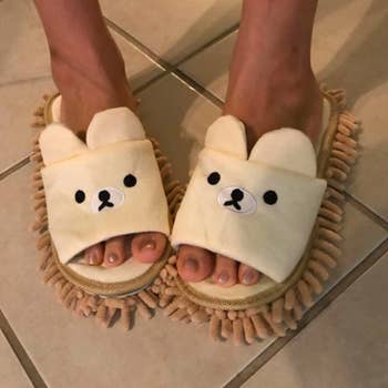 reviewer in open toe cream and tan slippers with teddy bear faces and microfiber fringe