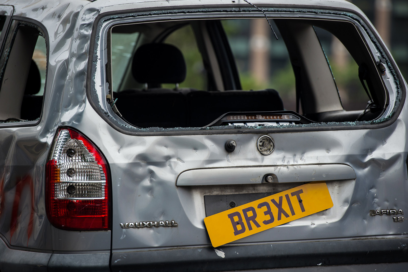 A banged-up car decorated with a banner saying "For sale — but no one's buying May's Brexit banger" is driven around Parliament Square on July 12 in London.