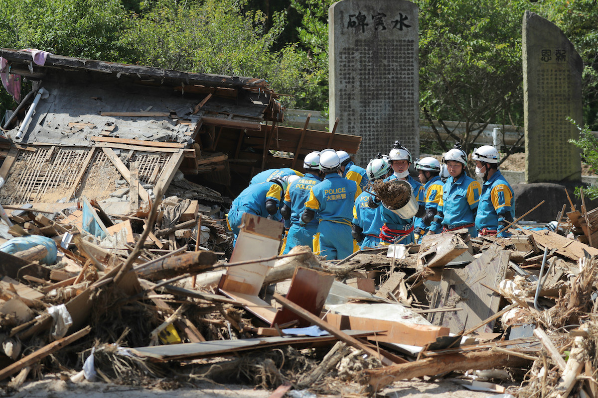 不明者を捜索する警察の救助隊員(13日、広島県坂町小屋浦)。猛暑や衛生環境の悪化で感染症のリスクが高まることが心配される