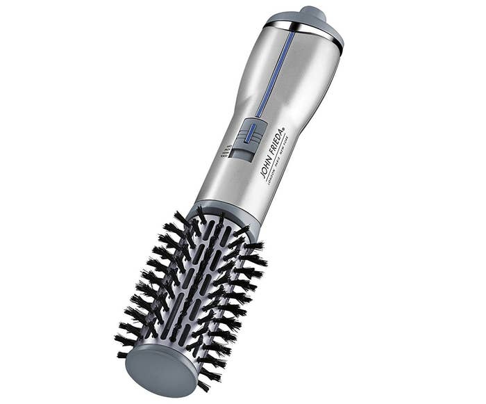 The brush, with vents that blow hot air and bristles to smooth hair
