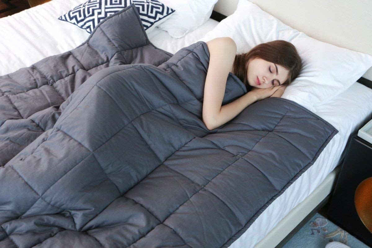 model sleeps under quilted blanket 