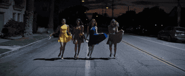 gif from movie &quot;La La Land&quot; of four people dancing down the street while wearing dresses