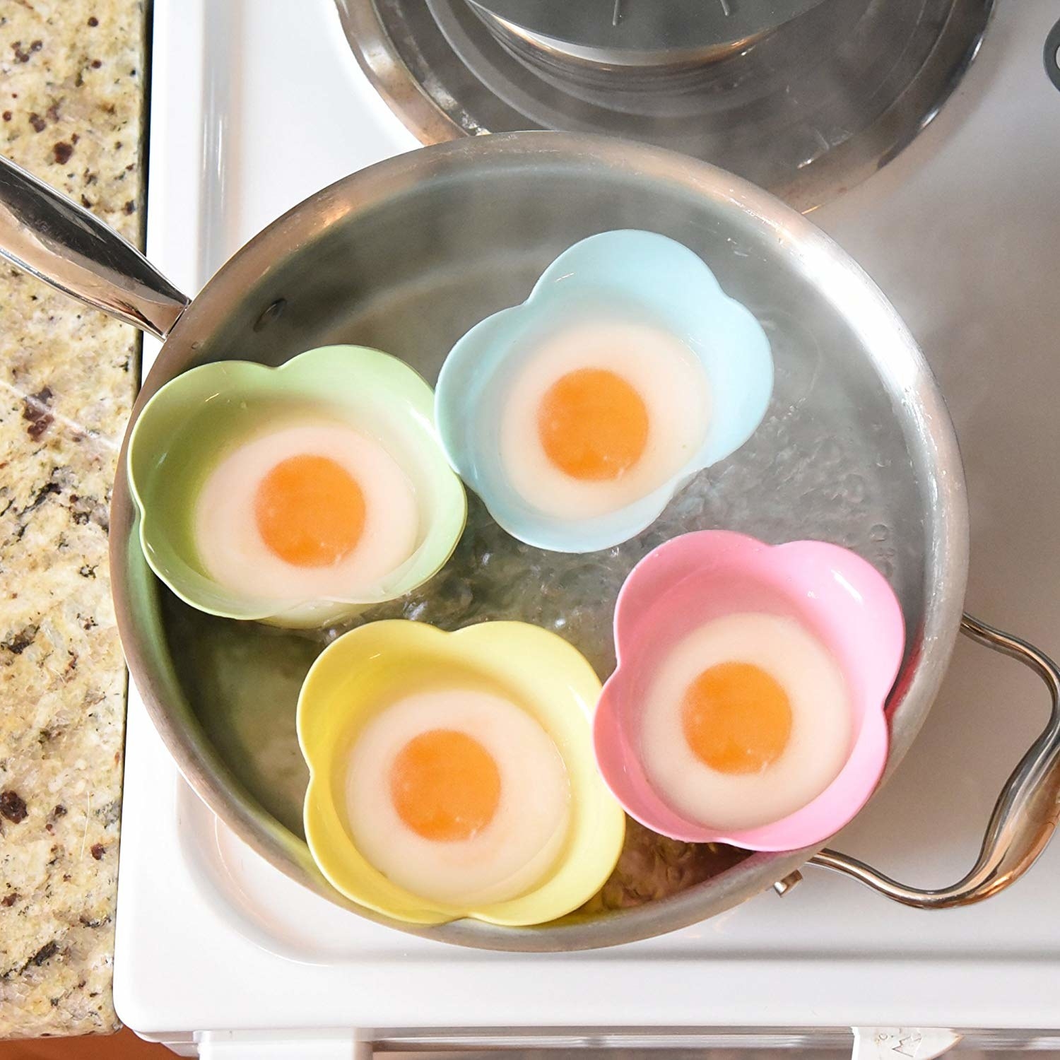 Four eggs being boiled while inside of the silicone cups