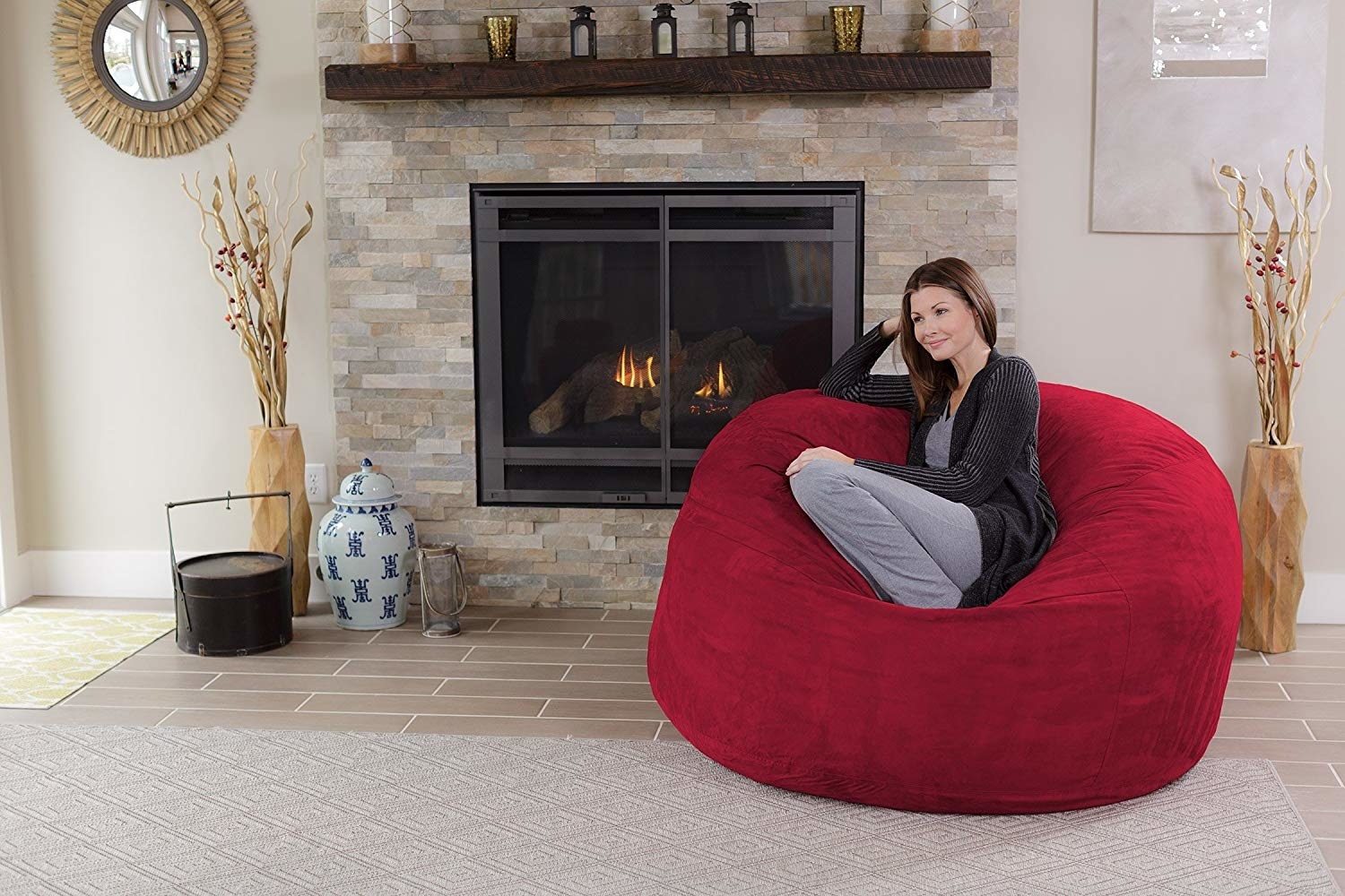 The big bean bag chair in red with a model sitting in it in a living room