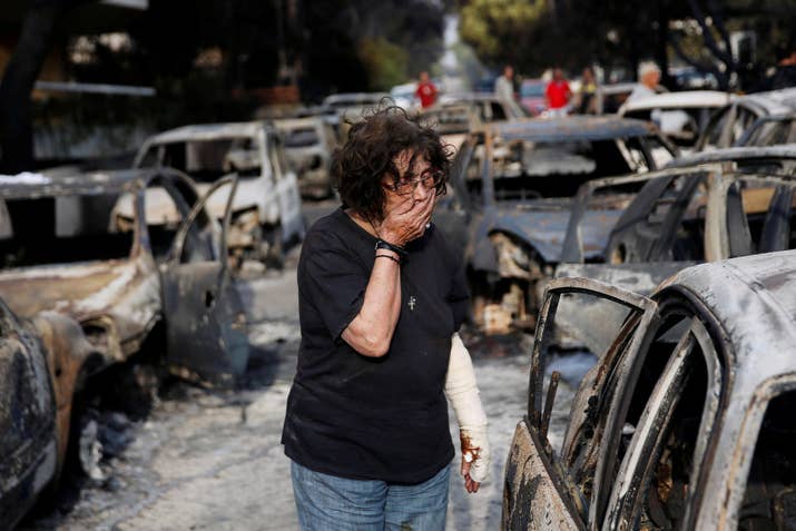 A woman tries to find her dog following a wildfire at the village of Mati, near Athens.