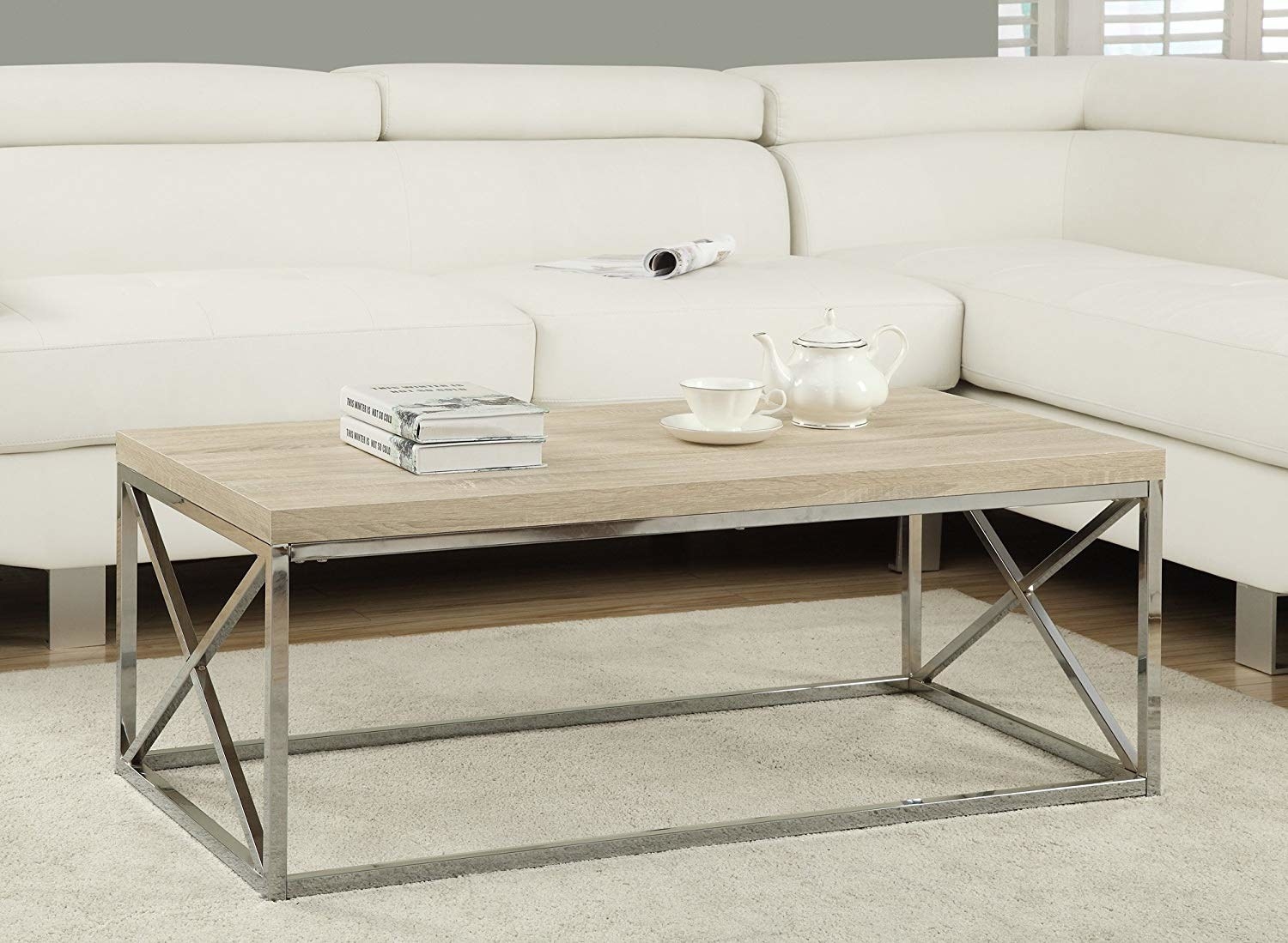 The coffee table with a light brown wood top and silver legs