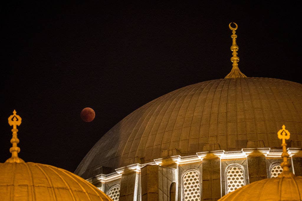 A blood moon is seen behind a dome of the Suleymaniye Mosque in Istanbul, Turkey.