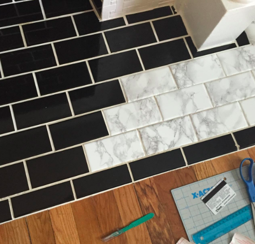 black tiles with some covered in the marble contact paper 