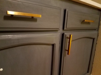 two drawers and a cabinet with matte gold rectangle drawer pulls