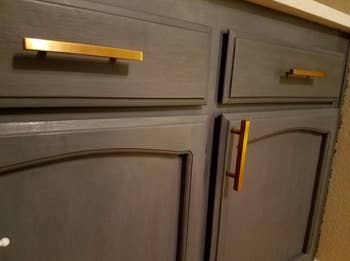 two drawers and a cabinet with matte gold rectangle drawer pulls