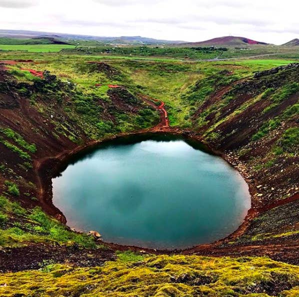 You can&#x27;t miss the pop of color that is Kerid crater. It&#x27;s a teal blue lake surrounded by red and burnt orange volcanic rock and green hills, and it&#x27;s been around for thousands of years. There&#x27;s a pathway that takes you around the rim and down to the bottom of the crater.