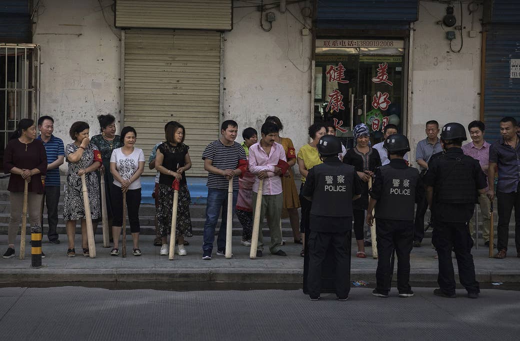 こん棒を手に持って安全対策の訓練を受ける、ウイグル人と漢人の店主たち。新疆ウイグル自治区の南西部にある古い街、カシュガル市の近郊で、2017年6月27日撮影。