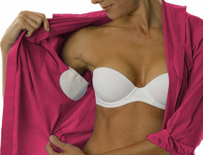 Model wearing the pads inside a shirt by the underarm area, which look like large panty liners