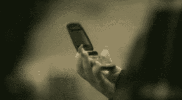 A GIF of Adele slamming her flip phone shut from the &quot;Hello&quot; music video.