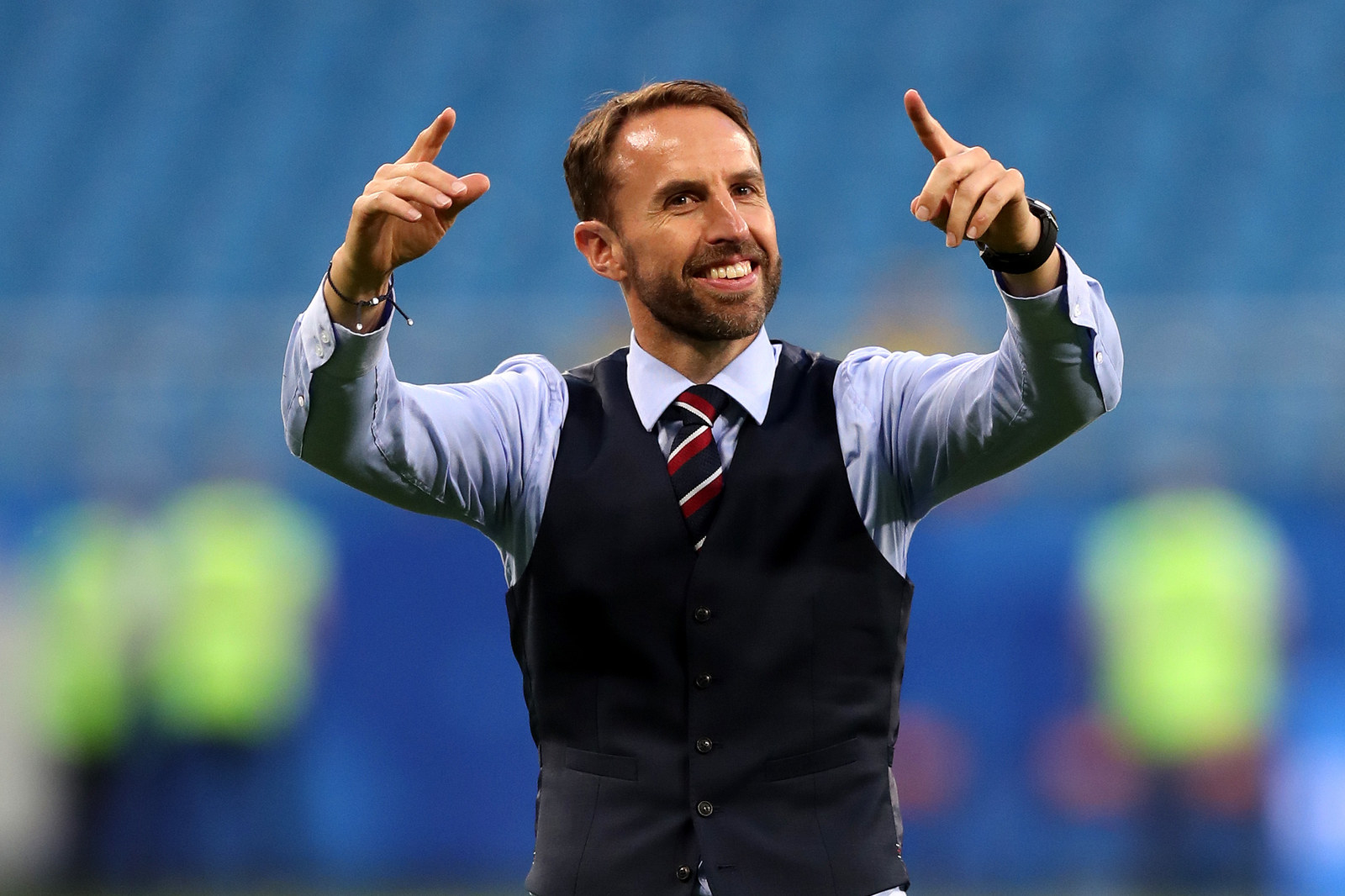  Gareth Southgate, the manager of the England football team, is pictured in a suit and tie celebrating a goal.