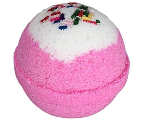 a pink birthday cake bath bomb with rainbow sprinkle decorations
