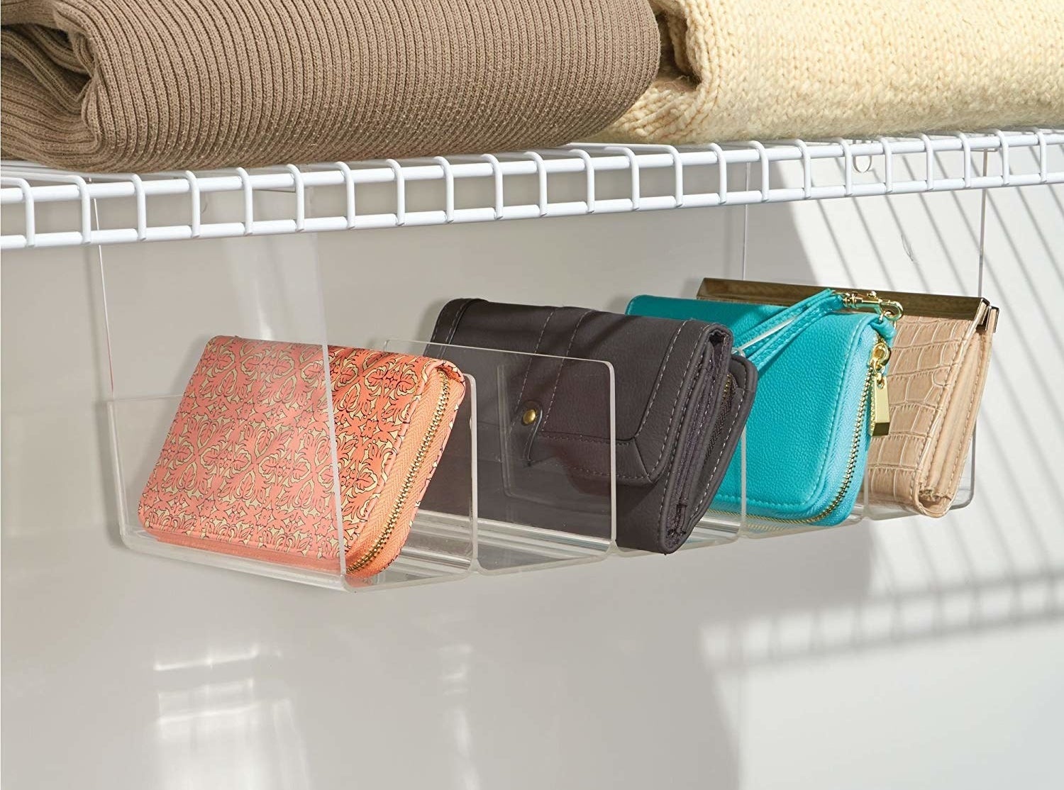 The hanging tray under a shelf with four wallets in it