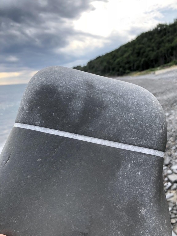 A rock with a perfectly straight line of quartz going through the middle of it