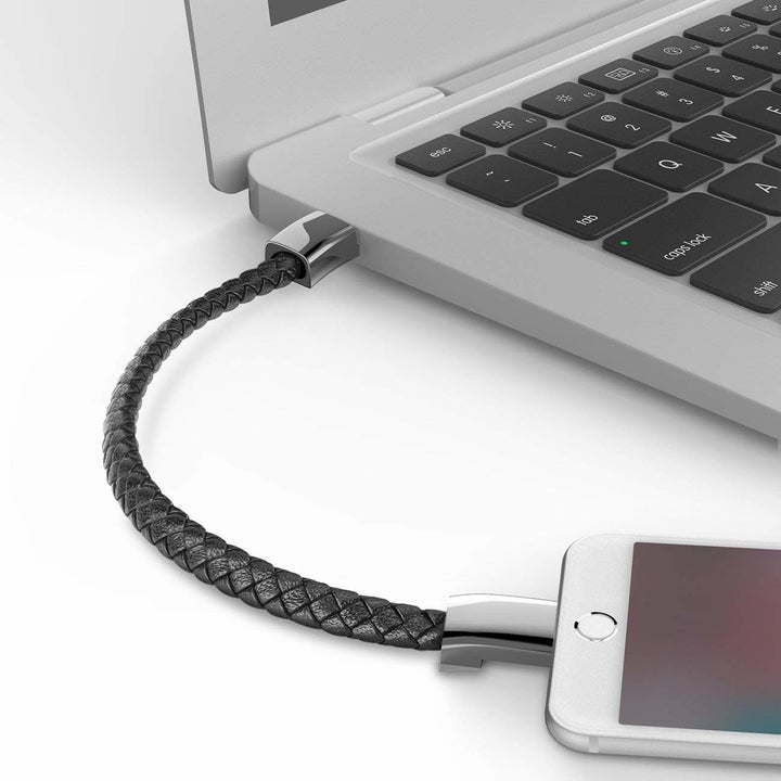 The cord being used to charge an iPhone through a computer 