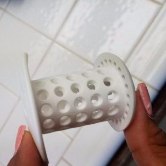 A reviewer holding the white drain plug