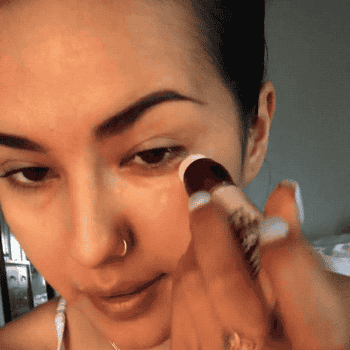 gif of BuzzFeed editor applying the concealer under eyes 