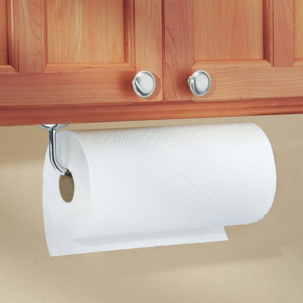 paper towel roll on a holder mounted on the bottom part of a cabinet 