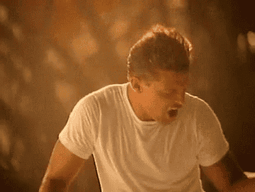 A gif of Luis Miguel dancing in a white T-shirt