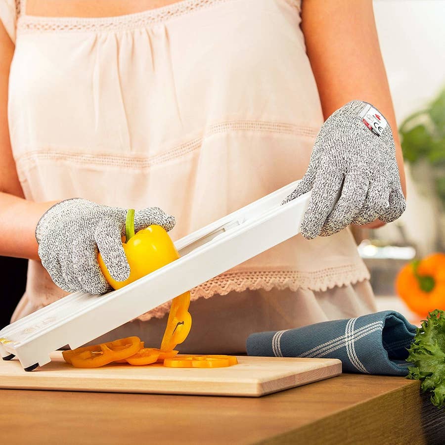person wearing cut resistant gloves handling paper cutter blade