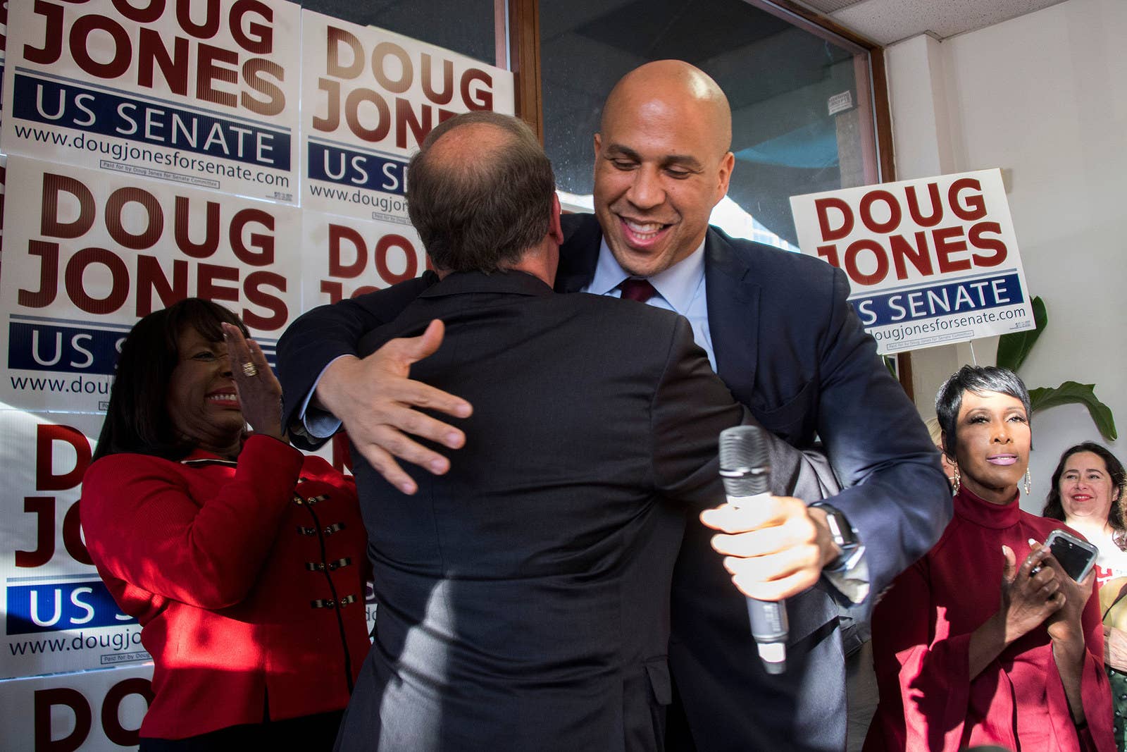 Rep. Terri Sewell, left, applauds as Sen. Cory Booker hugs Democratic Senate candidate Doug Jones at his campaign headquarters in Birmingham, Alabama, on Dec. 10, 2017.