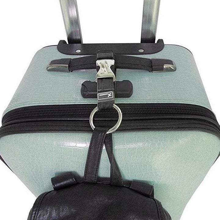 strap holding additional carry on item to suitcase