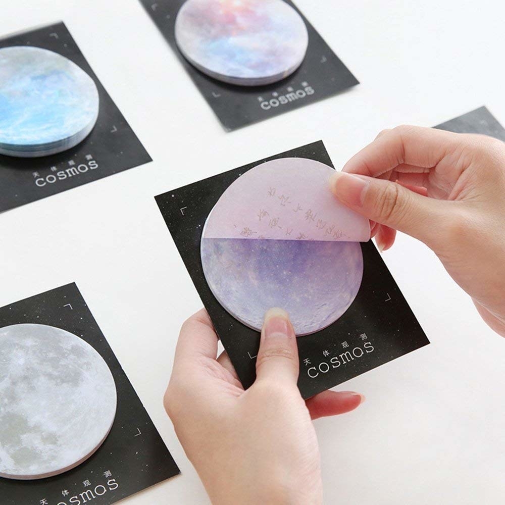 model pulls a pink moon sticky note