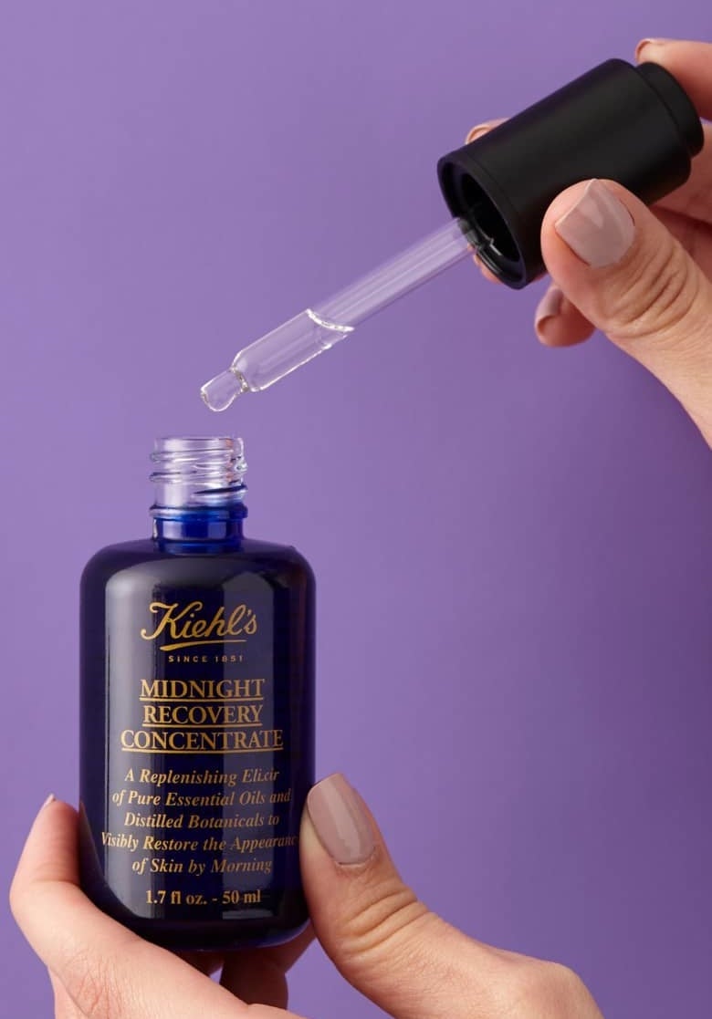 model&#x27;s hands holding the serum bottle and the dropper
