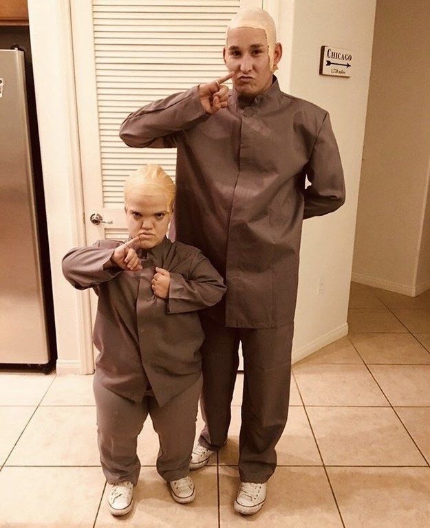 Two people dressed as Dr. Evil and Mini-Me in their gray outfits