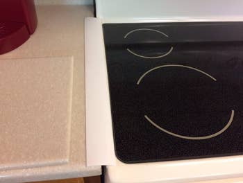 The narrow cover placed between a countertop and stovetop, covering the gap