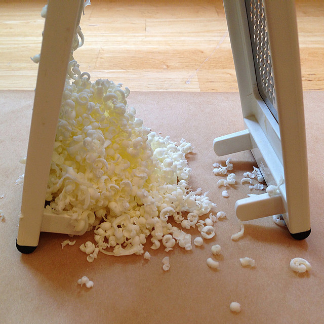 Cheese grater with pile of grated butter to the side