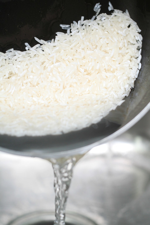 Close-up of bowl with rice filled with water being drained