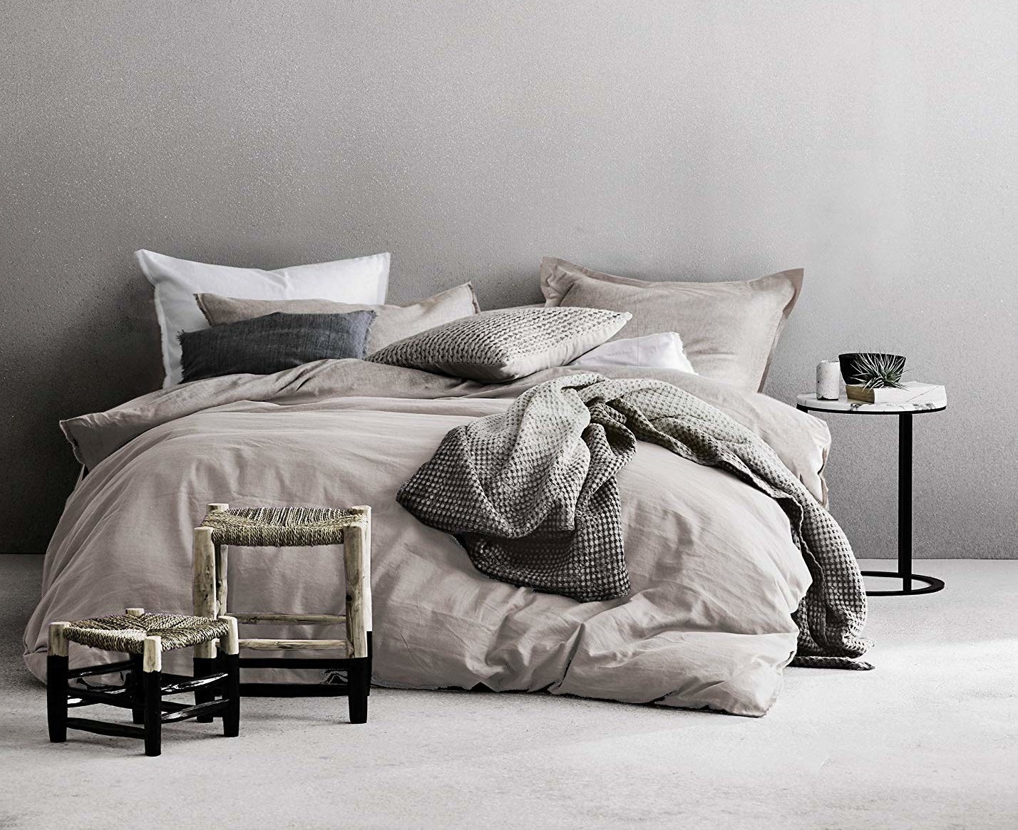 the grey duvet set with pillows and a blanket in different shades of grey