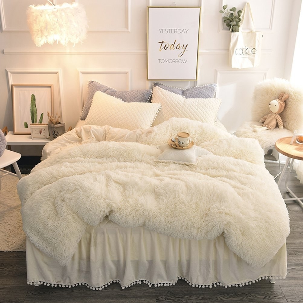 the off white faux fur duvet set on a bed