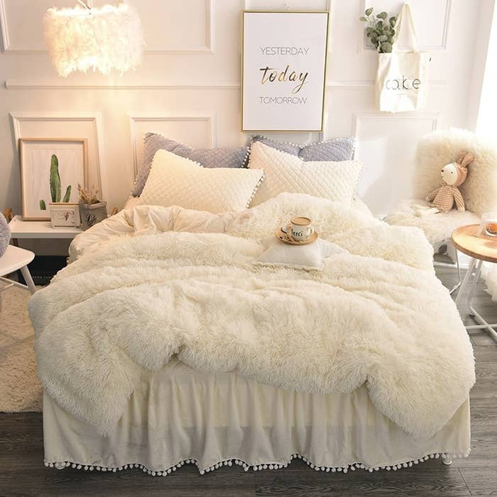 A photo of the off white faux fur duvet set on a bed