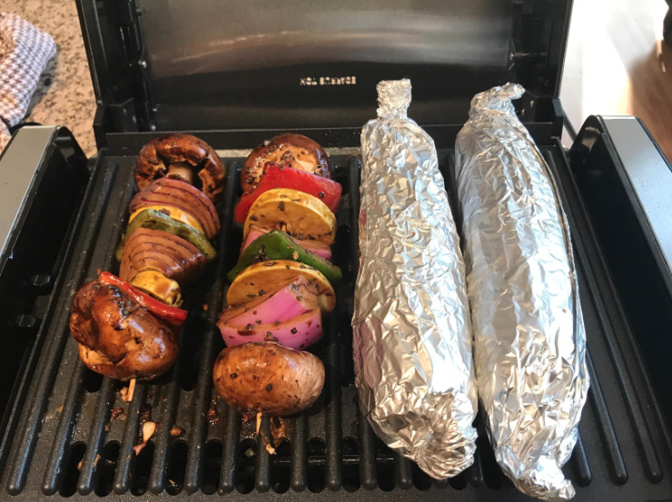 reviewer grilling kabobs and corn on the cob