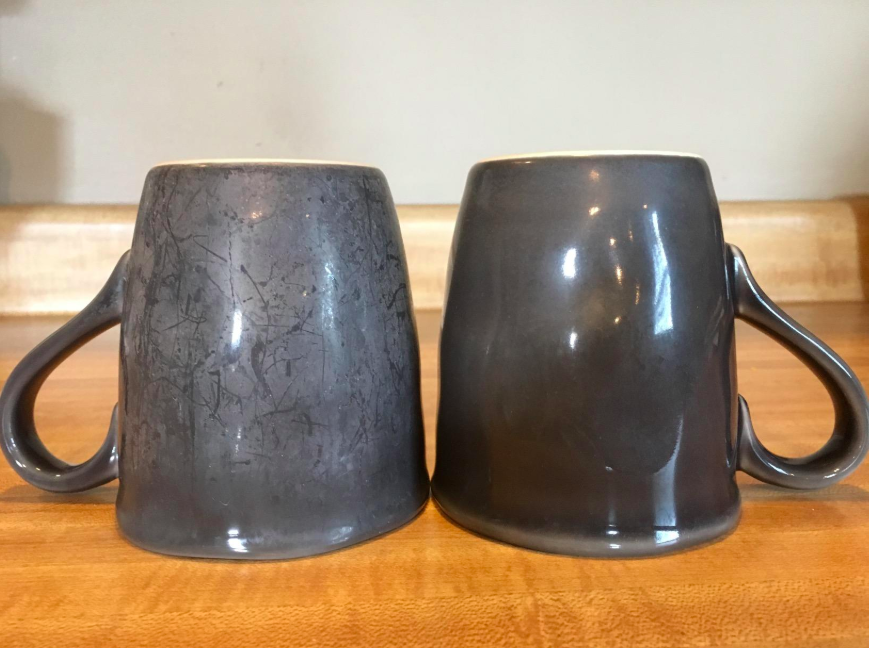 A stained mug next to a clean mug after using powder