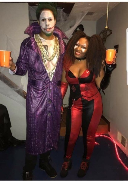 Two people dressed as the Joker and Harley Quinn in the iconic purple and red outfits