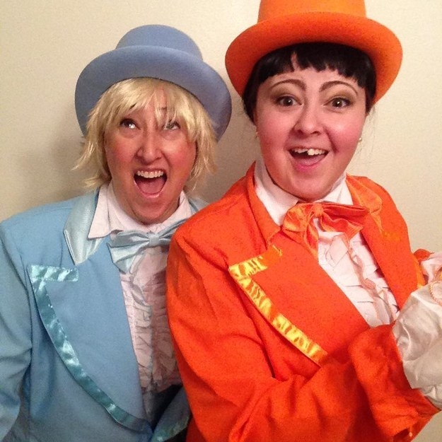 Two people dressed in the orange and light-blue suits as Harry and Lloyd