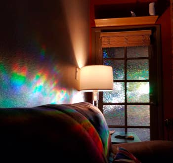 Light shining through a window with the film and projecting rainbow patterns on a wall