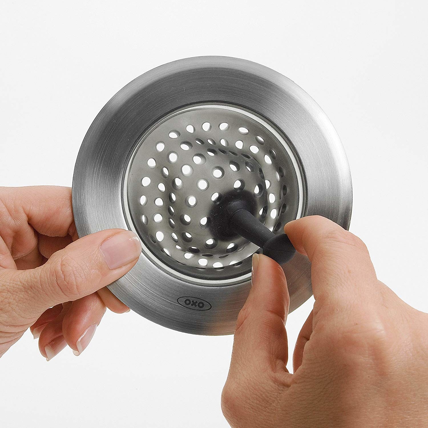A person flexing the sink strainer