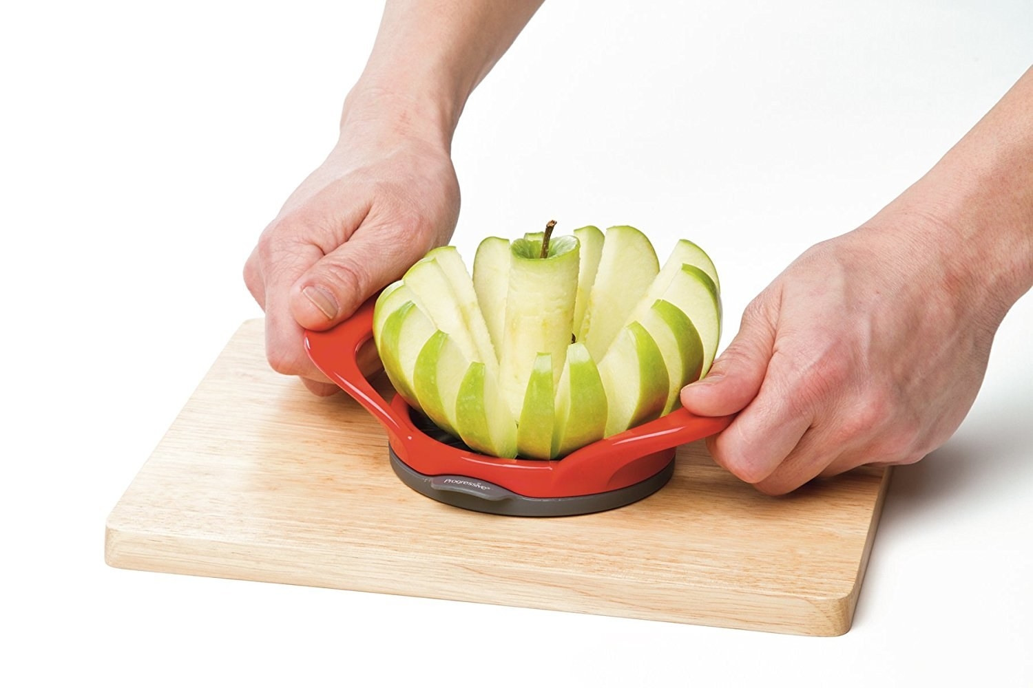 A person cutting an apple with the slicer