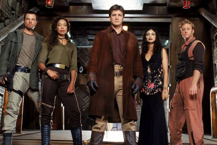 Characters from Firefly standing together, including Malcolm Reynolds in the center