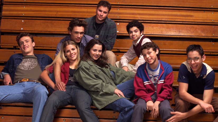 Teens sitting on high school bleacher seats together